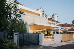 A modern home exterior with white concrete and wooden accents.