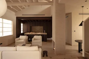 A minimalist living room with wooden furniture and a white sofa.
