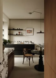 A modern kitchen with industrial elements, featuring marble countertops and wooden furniture.