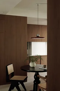 Minimalist dining room featuring wooden furniture and glass elements.