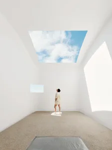 A minimalist sculpture gallery with concrete walls and natural light.