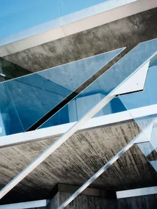 A modern architectural structure featuring glass, steel, and concrete materials.