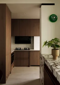 Modern kitchen with wooden cabinets and marble countertop.