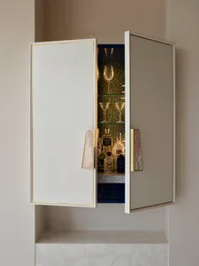 A modern bar cabinet featuring a concrete finish, with bottles, glasses, and other bar essentials inside.