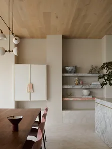 Modern dining room featuring marble countertops, concrete bases, and wooden furniture.