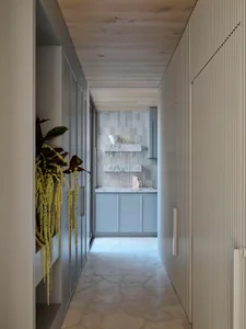 Modern kitchen featuring marble surfaces and white cabinetry, with a minimalist design.