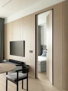 Modern, minimalist bedroom with wood flooring, light-colored wooden paneled walls, a built-in entertainment center with a mou