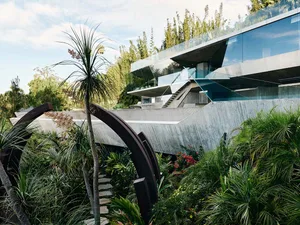 A modern residential house with concrete and glass exterior.