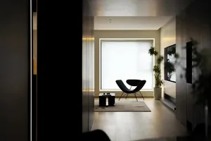 A minimalist living room featuring concrete flooring and a modern lamp.