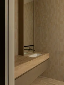 Modern minimalist bathroom featuring a wooden countertop with a sink and faucet.