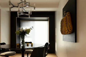 Modern interior design featuring a glass window with black frame, white blinds, and a round glass table with black chairs.