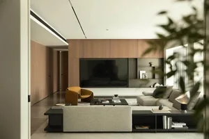 A modern minimalist living room with a wooden accent wall, a comfortable seating arrangement, and a television mounted on the