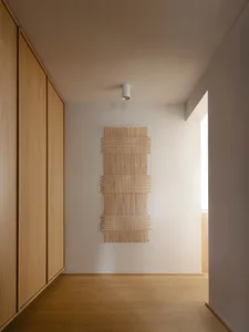 A minimalist interior with a wooden texture wall hanging