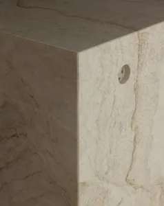 Modern interior design featuring a marble pedestal with a sculptural abstract form, against a minimalist backdrop, and hardwo