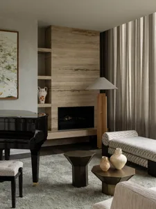 Contemporary living room with minimalist design, marble fireplace, and patterned textiles.