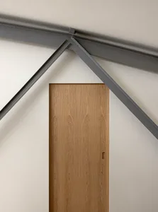 A modern, wooden door framed by steel beams.