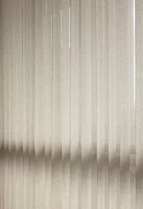 Striped taupe textile curtain hanging in a window.