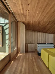 A modern industrial living room with wooden paneling and furniture.