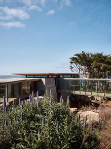 Modern architectural design featuring glass and stone materials.