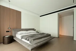 A modern bathroom with a wooden accent wall and a plush leather-textured bedspread.