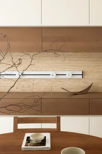 A modern minimalist kitchen with wooden cabinets and a mixed material design.