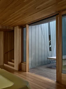 A modern patio featuring glass walls and sliding doors.