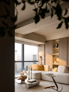 Modern minimalist living room with white sofas, a coffee table, and a view of a cityscape through large windows.