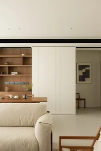 A modern minimalist living room with wooden furniture, a white sofa, and a wooden coffee table featuring a small plant.