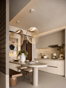 A modern minimalist kitchen featuring sleek, white countertops and a central island with a concrete pillar base. The space in