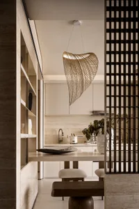 Minimalist kitchen with white cabinets and modern lighting fixture.