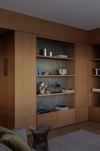 A modern residential interior with wooden shelves and concrete accents.
