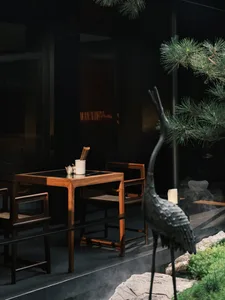 A minimalist restaurant interior with wooden furniture and greenery.