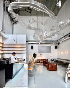 A modern restaurant with a metal and glass ceiling art installation