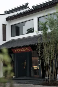 A classical storefront with a black wooden frame and glass doors.