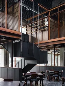 Industrial-style interior space featuring black metal structures, wooden panels, and glass elements.