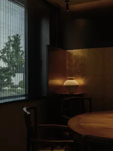Modern dining room featuring a ceramic vase on a table.