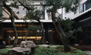 An elegant, modern restaurant interior with concrete flooring and a minimalist design.
