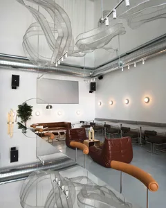 Modern coffee shop interior with metal, leather, and glass furniture.