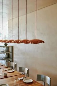 A minimalist restaurant interior featuring metallic lighting.