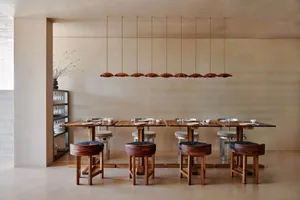 Modern restaurant interior with wooden furniture and a minimalist design.