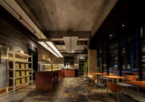 Interior of an industrial-themed coffee shop featuring concrete walls and floors.