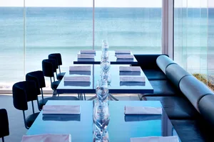 Modern table setting with glassware and folded napkins in a coastal restaurant setting