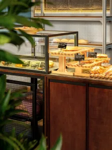 A bakery interior with wooden shelves displaying various pastries and breads.