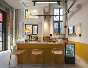 Industrial style cafe bar with wooden seating and concrete walls and floor