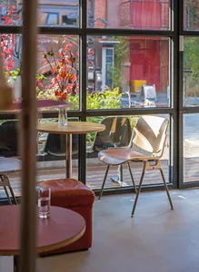 Industrial-style coffee shop with a view of the street featuring wooden furniture, glass walls, and metal elements