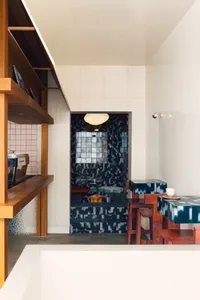 Modern industrial interior design with concrete walls and wooden furniture in a restaurant setting.
