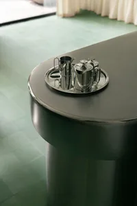 A metallic coffee station with a sleek, industrial design in a modern interior setting.