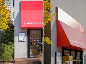 A modern storefront with a red metal canopy.