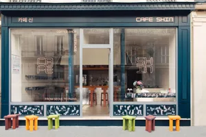Front facade of a modern coffee shop featuring glass windows and a metal-framed entrance.