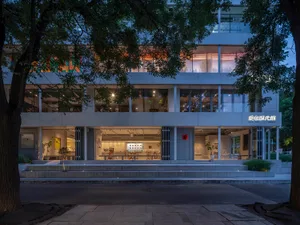 Modern building exterior with illuminated windows during night.